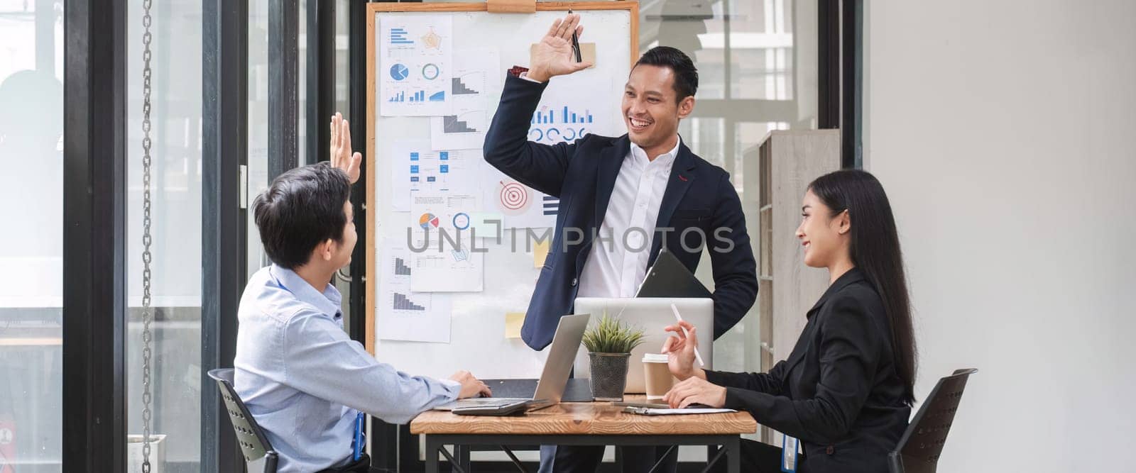 colleagues asking a question to a businessman during a presentation. by wichayada