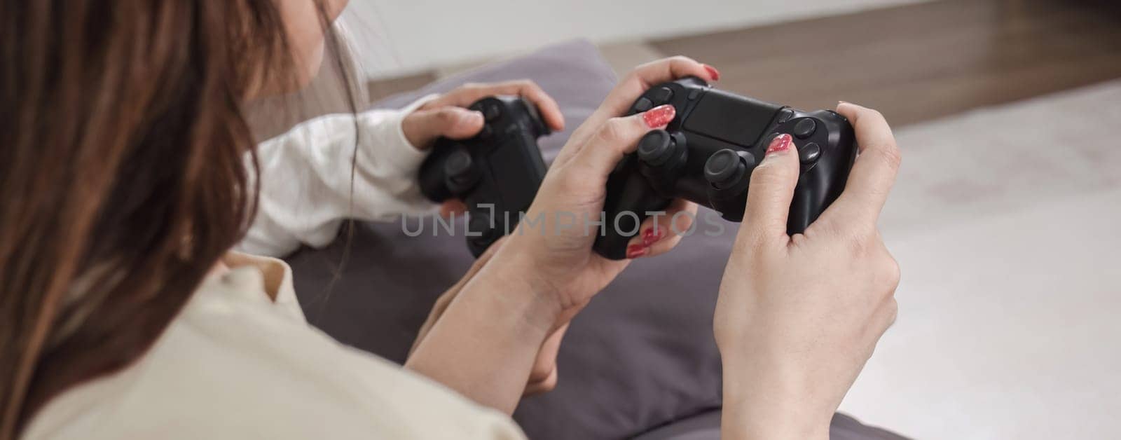 Close-up of the women couple enjoying playing video games with a console gamepad in their hands..