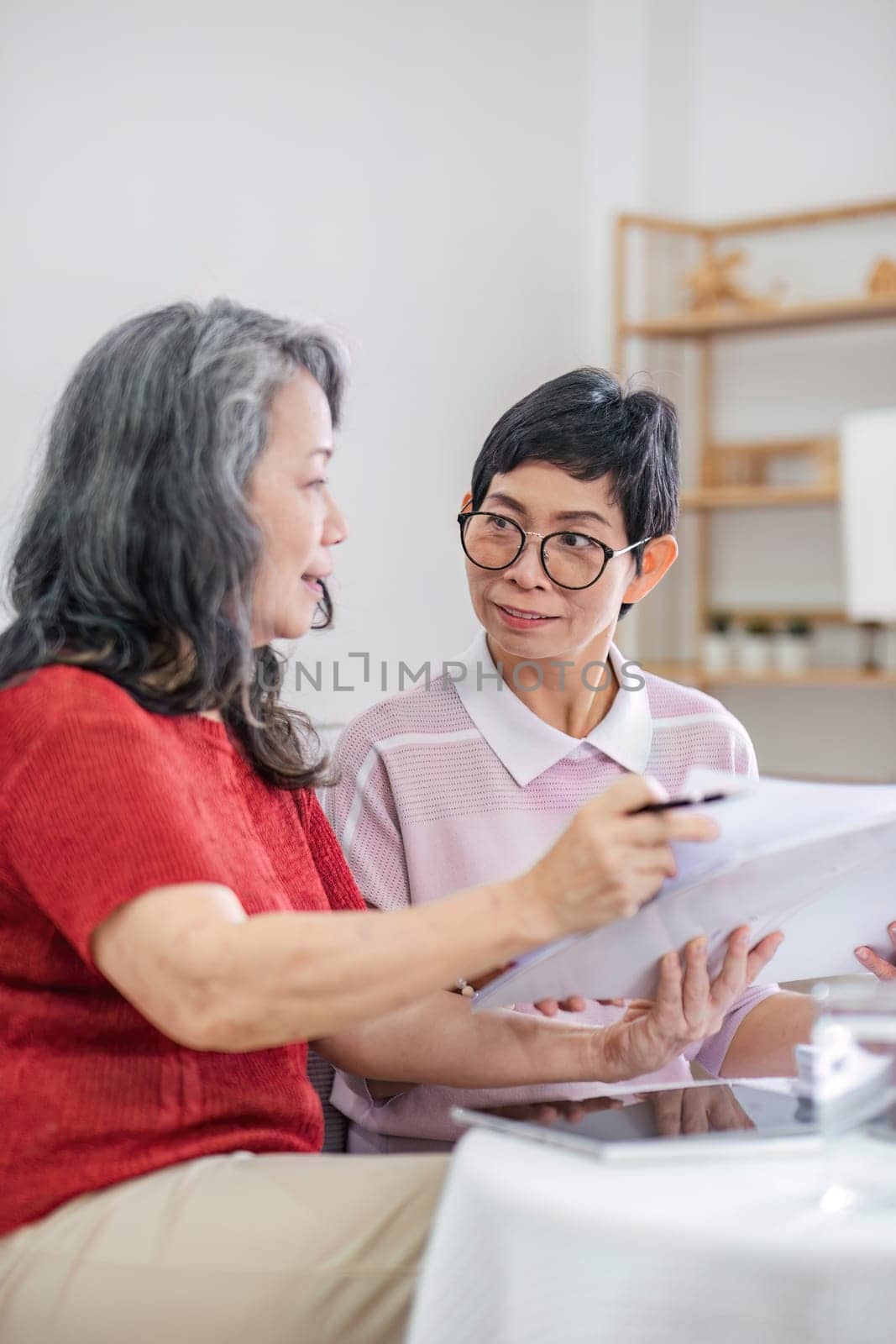 Senior woman planning future life insurance and finance happily in the living room..