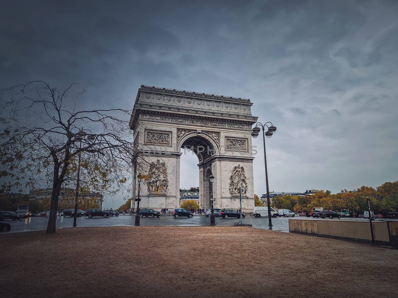 Arc de triomphe in Paris, France. Rainy autumn day with a romantic view to the triumphal arch landmark from avenue by psychoshadow