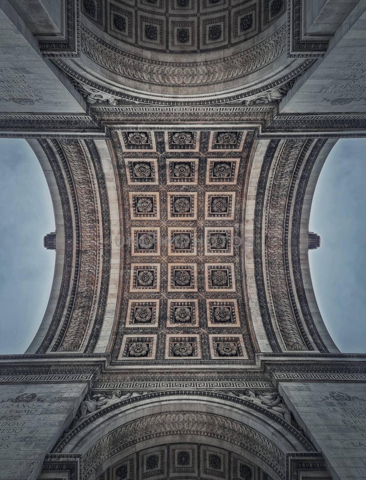 Closeup view underneath triumphal Arch, in Paris, France. Architectural details and ceiling ornate pattern of the famous Arc de triomphe landmark	