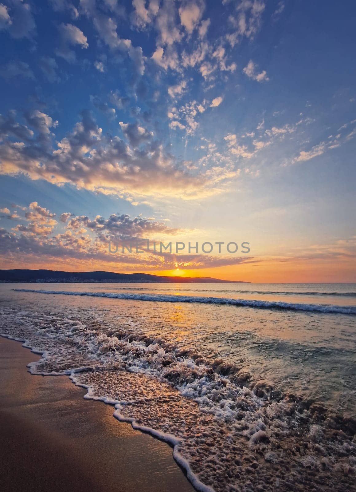 Seascape dawn scene, natural vertical background. Early morning on the beach with a peaceful view to the sunrise above the hills. Calm summer holiday, sea travel concept by psychoshadow