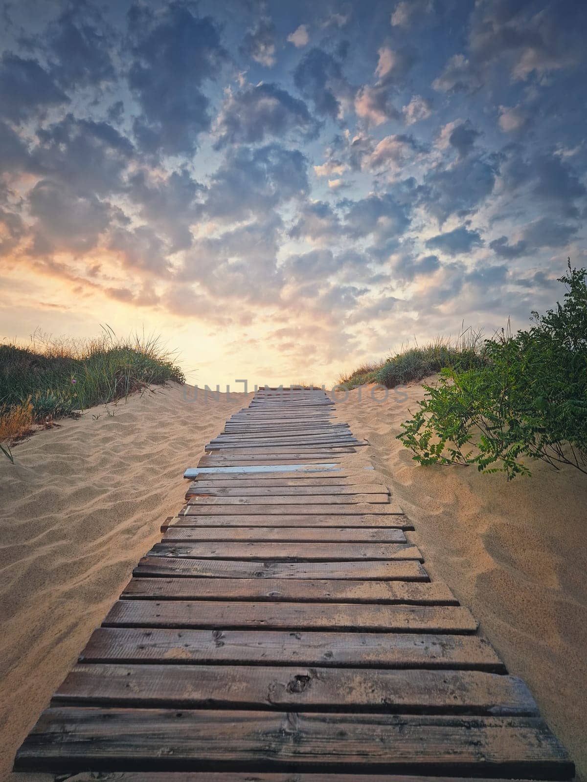 Wooden footpath through the sand leading to the beach. Beautiful morning sky with fluffy clouds by psychoshadow