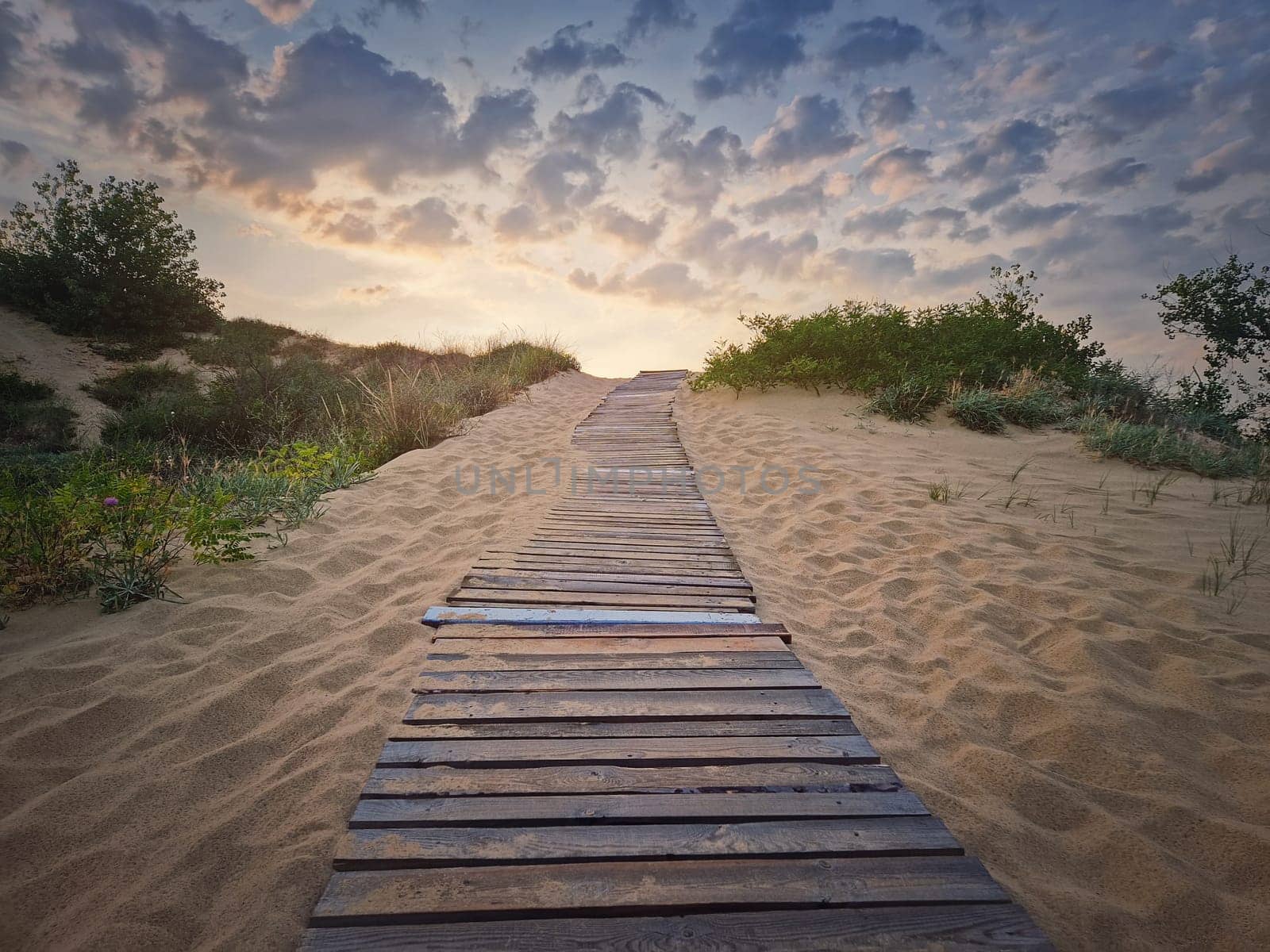 Wooden path through the sand leading to the beach. Beautiful morning sky with fluffy clouds by psychoshadow