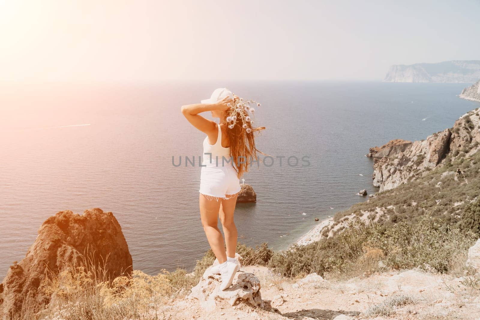 Woman travel sea. Young Happy woman in a long red dress posing on a beach near the sea on background of volcanic rocks, like in Iceland, sharing travel adventure journey