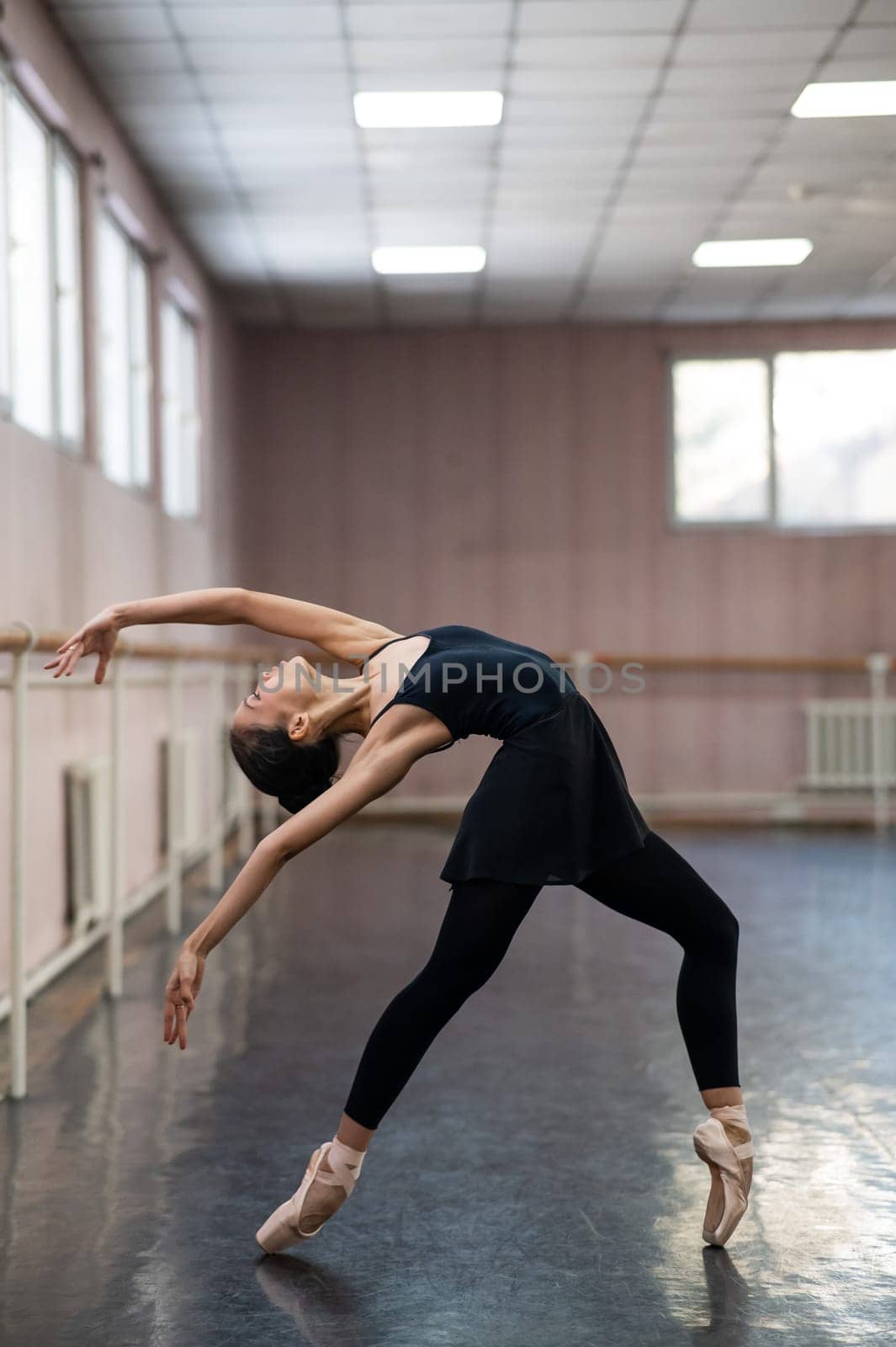 Asian woman dancing in ballet class. Bending in the back