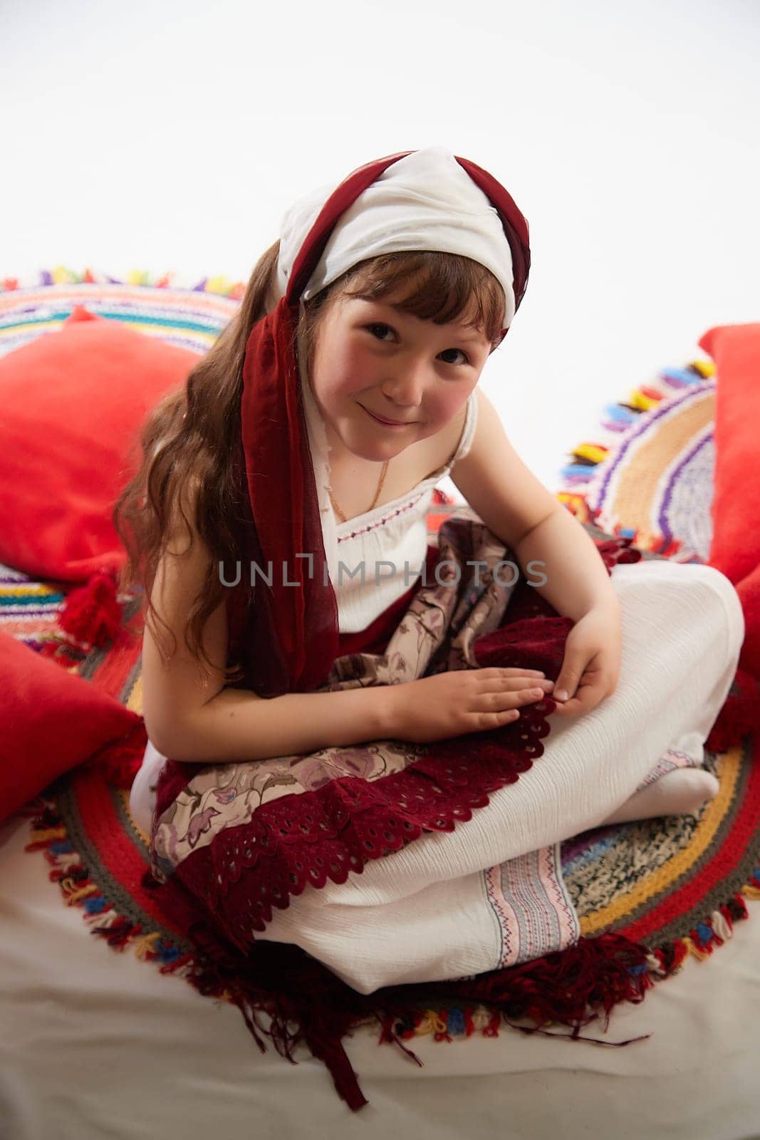 Portrait of Little girl in a stylized Tatar national costume on a white background in the studio. Photo shoot of funny young teenager who is not a professional model