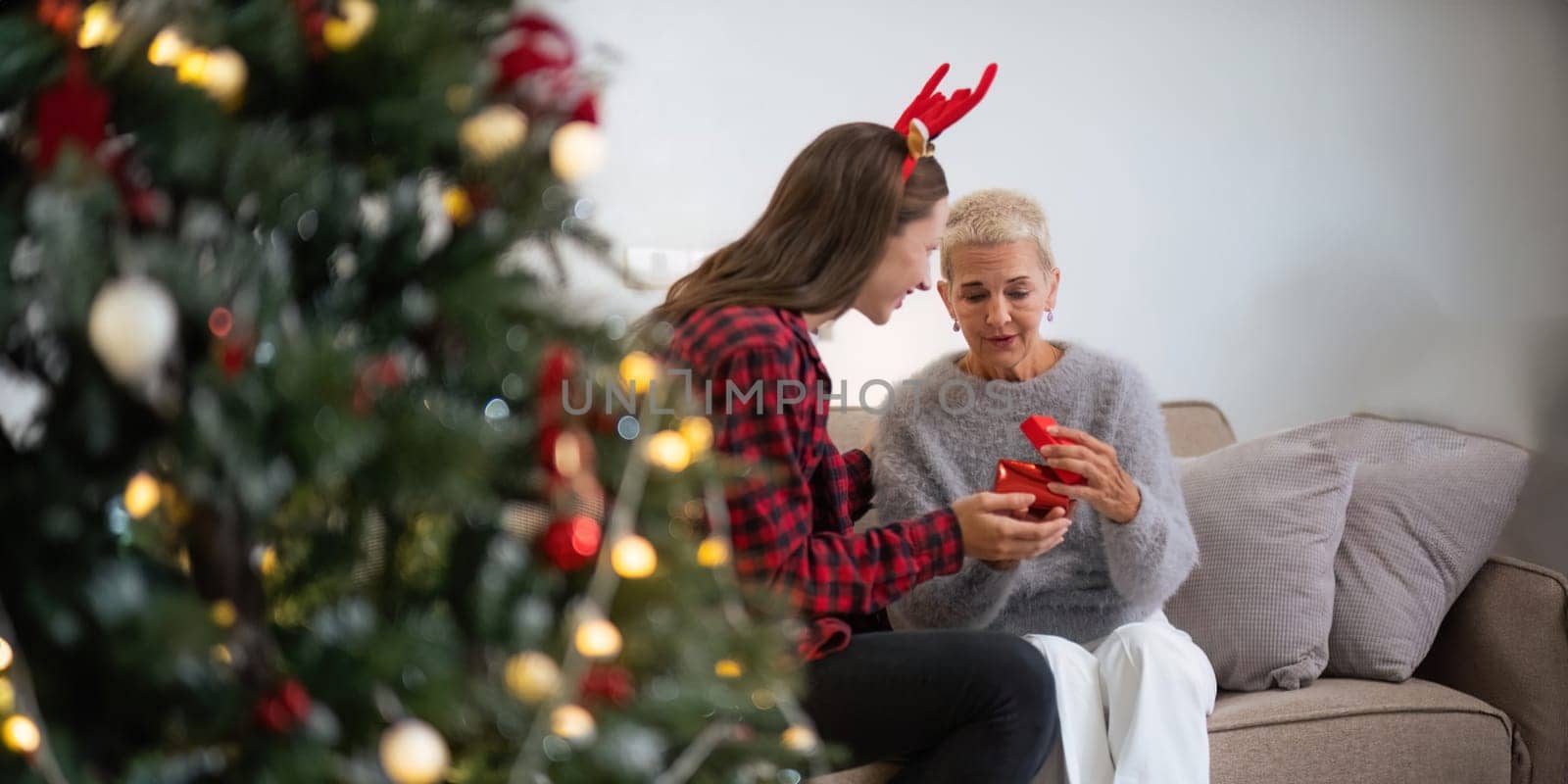 Caucasian Family, winter holiday and concept happy mother and daughter decorating Christmas tree and give a gift at home. concept holidays Christmas festive celebrate and tree Xmas seasonal.