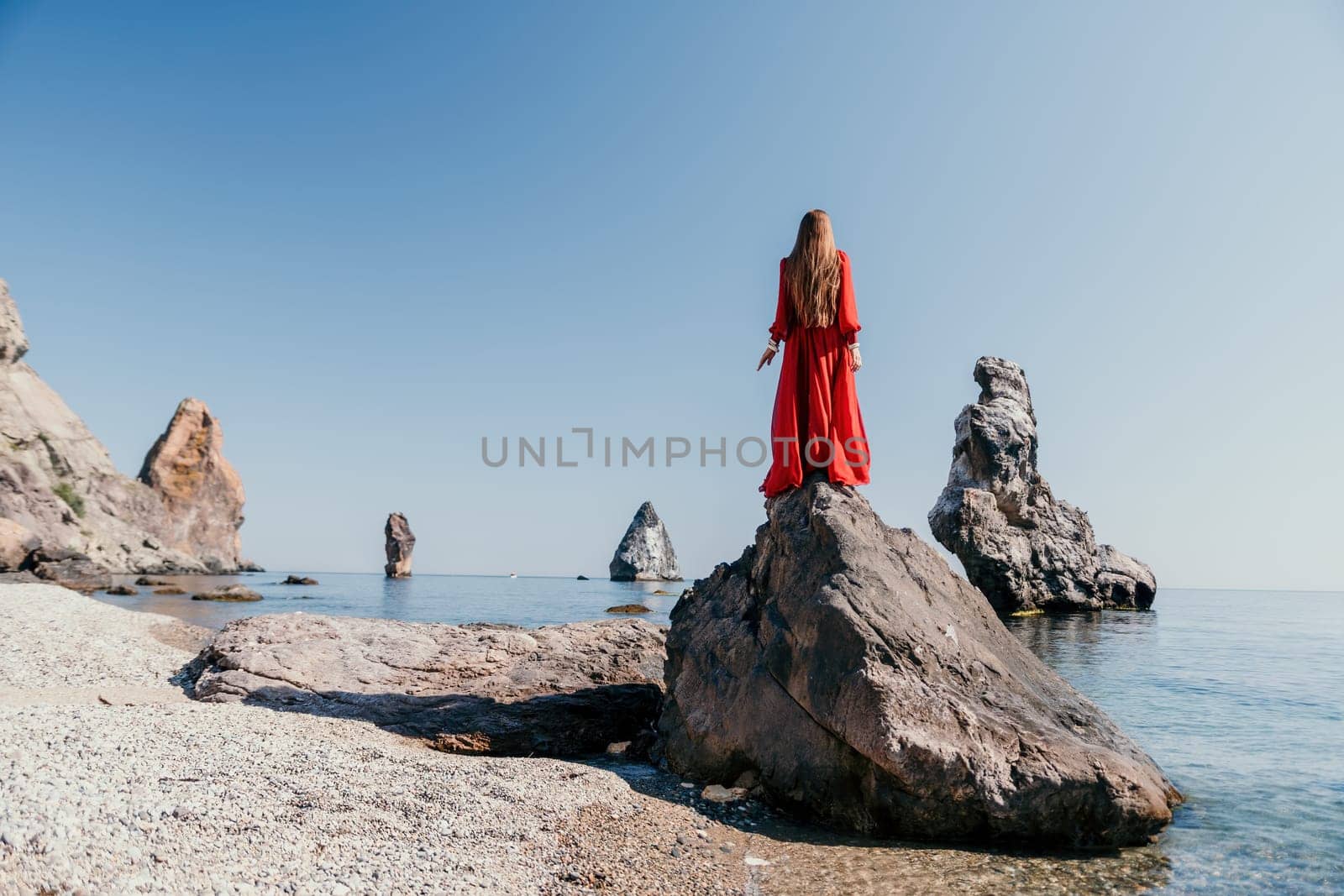 Woman travel sea. Happy tourist taking picture outdoors for memories. Woman traveler looks at the edge of the cliff on the sea bay of mountains, sharing travel adventure journey.