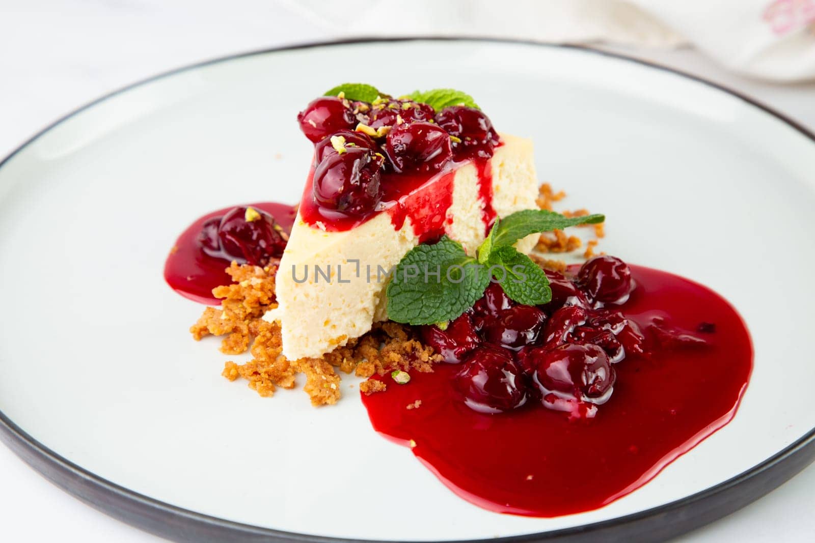 cheesecake with juicy berries and mint on a white plate