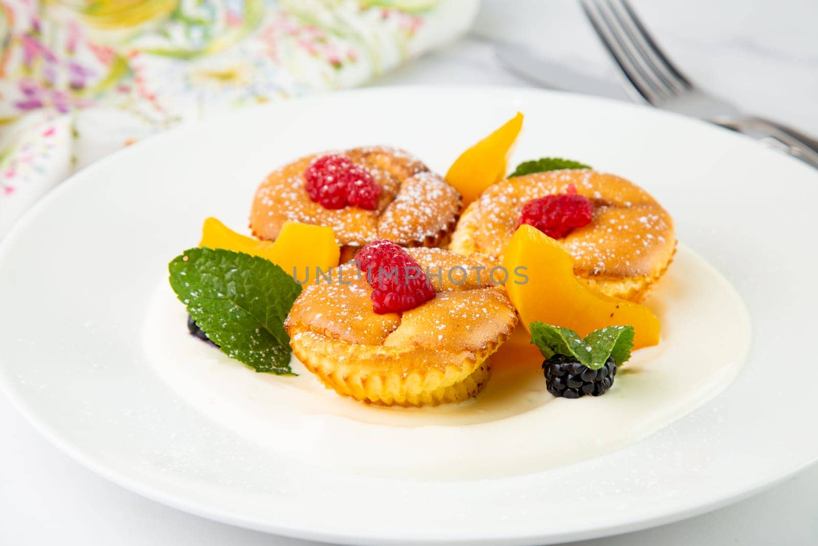 muffins with peach, raspberry, black berry and mint covered with powdered sugar