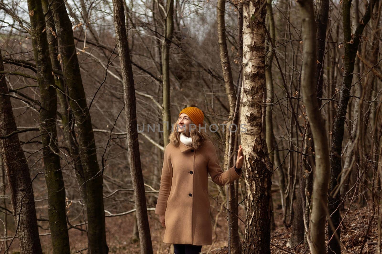 Woman in a brown coat in the forest