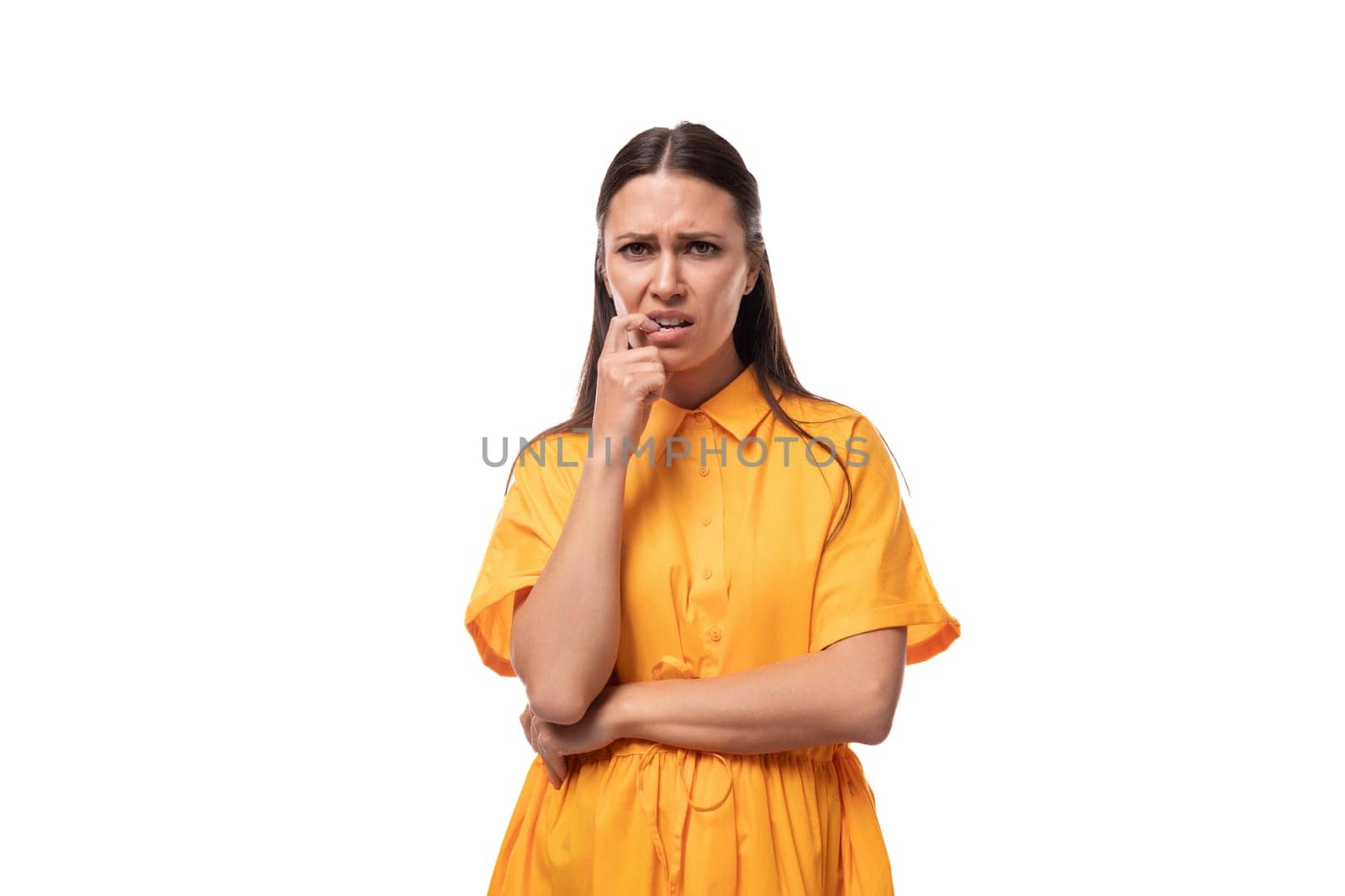 young brunette woman dressed in a summer yellow dress feels annoyed and frustrated by TRMK
