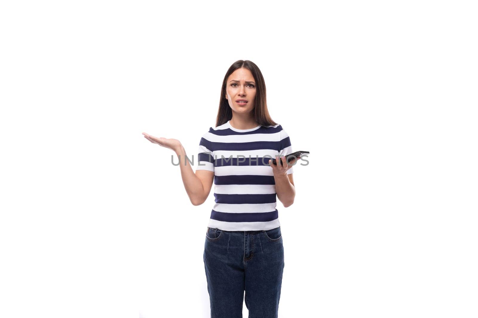 charming young european woman with black straight hair in a striped black and white t-shirt and jeans doubts spreading her arms.