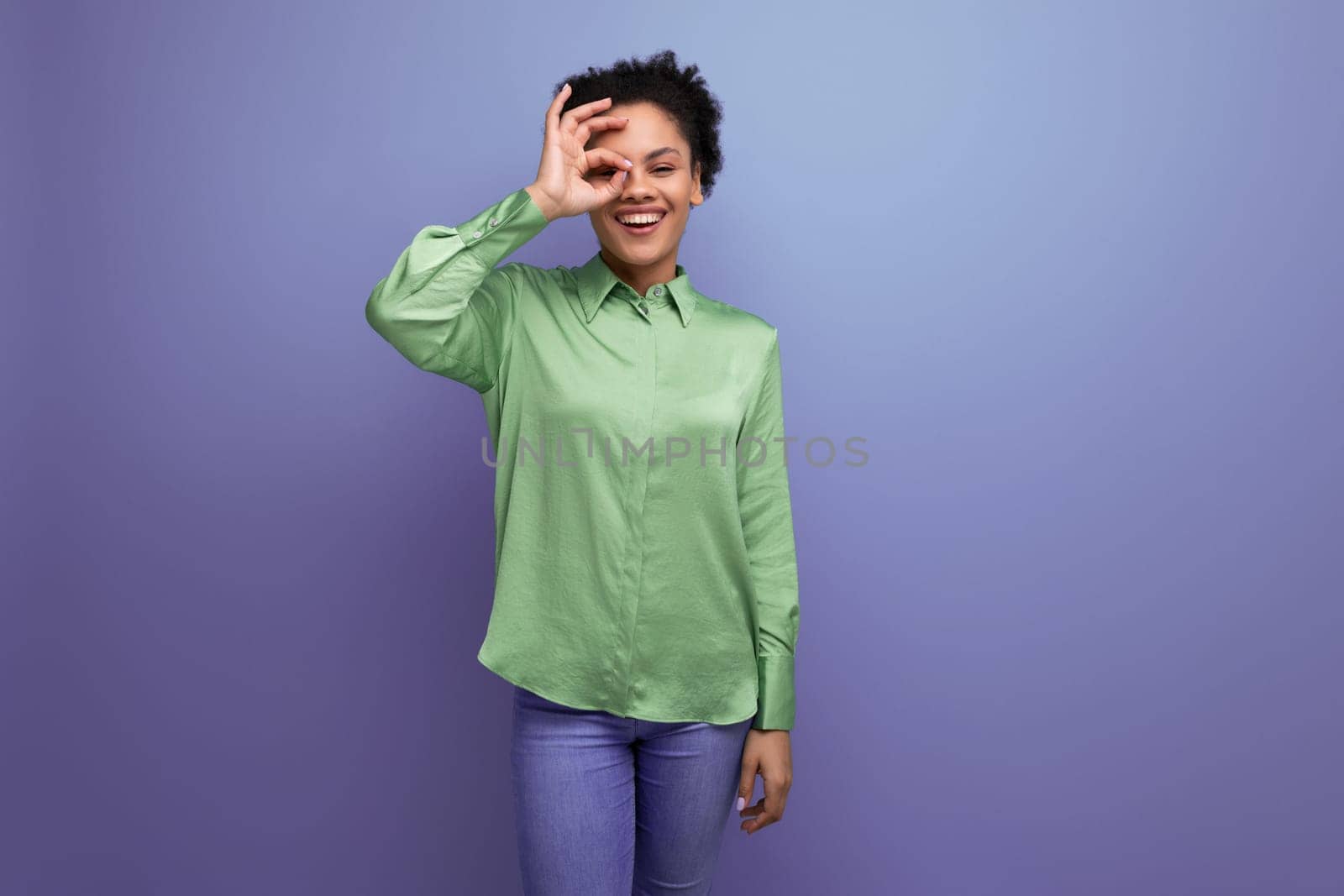 young bright cheerful latin woman dressed in a green blouse on the background with copy space by TRMK
