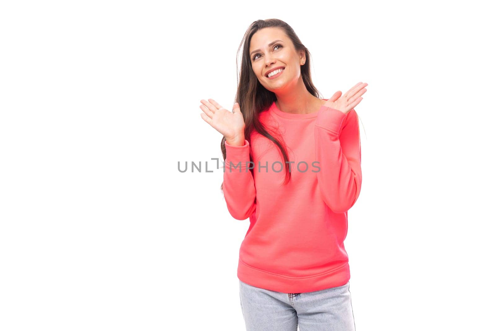 joyful happy young brunette european woman dressed in pink sweater over isolated background with copy space.