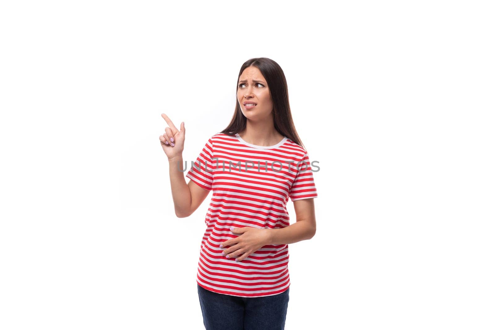 young brunette woman in a red striped t-shirt points her finger to the side.