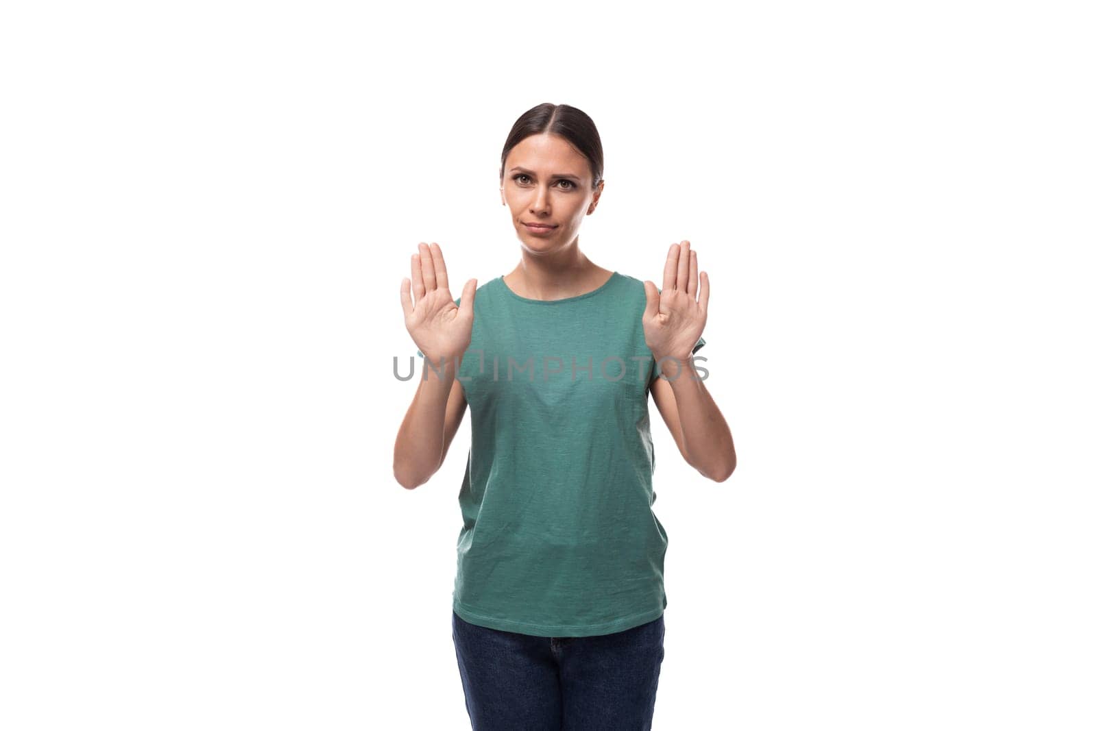 A 30 year old slender European brunette woman with a ponytail dressed in a green t-shirt and jeans is trying to remain calm.