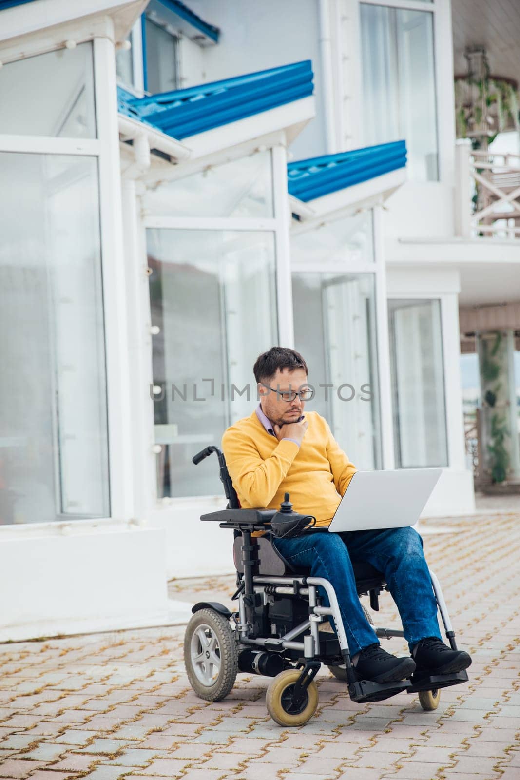A person with laptop outside a building on the street