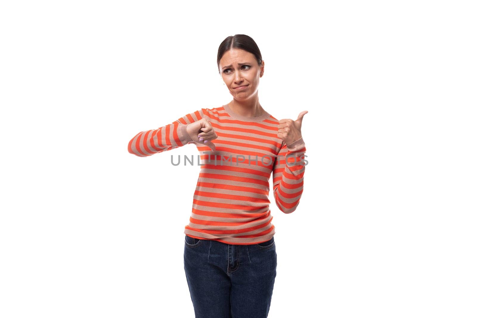 young slender adult woman with a ponytail dressed in an orange striped jacket and jeans is having doubts by TRMK