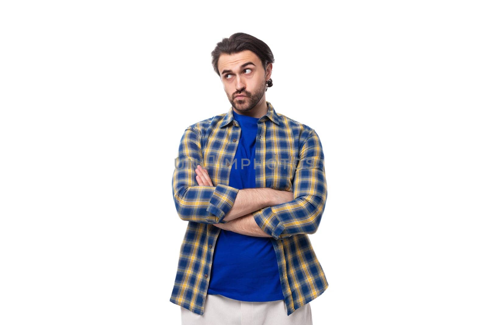 handsome brunet macho man with a beard in a blue shirt on a white background with copy space.