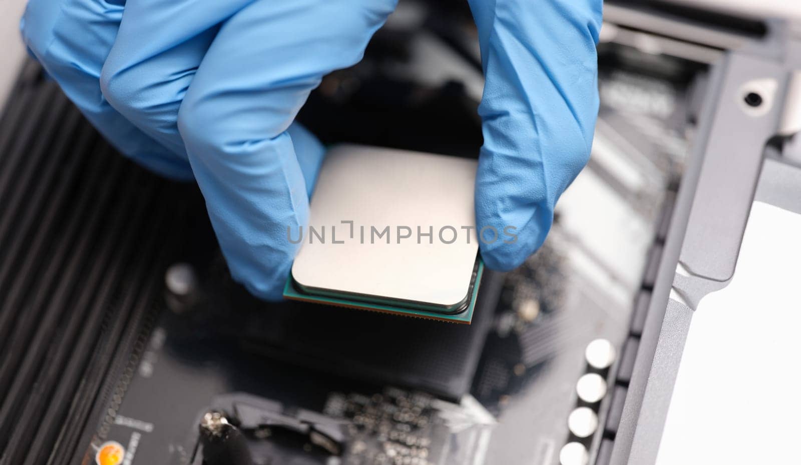 Technician examines microprocessor chip on PC motherboard. Electronic components repair concept. Hardware industry support digital technology concept