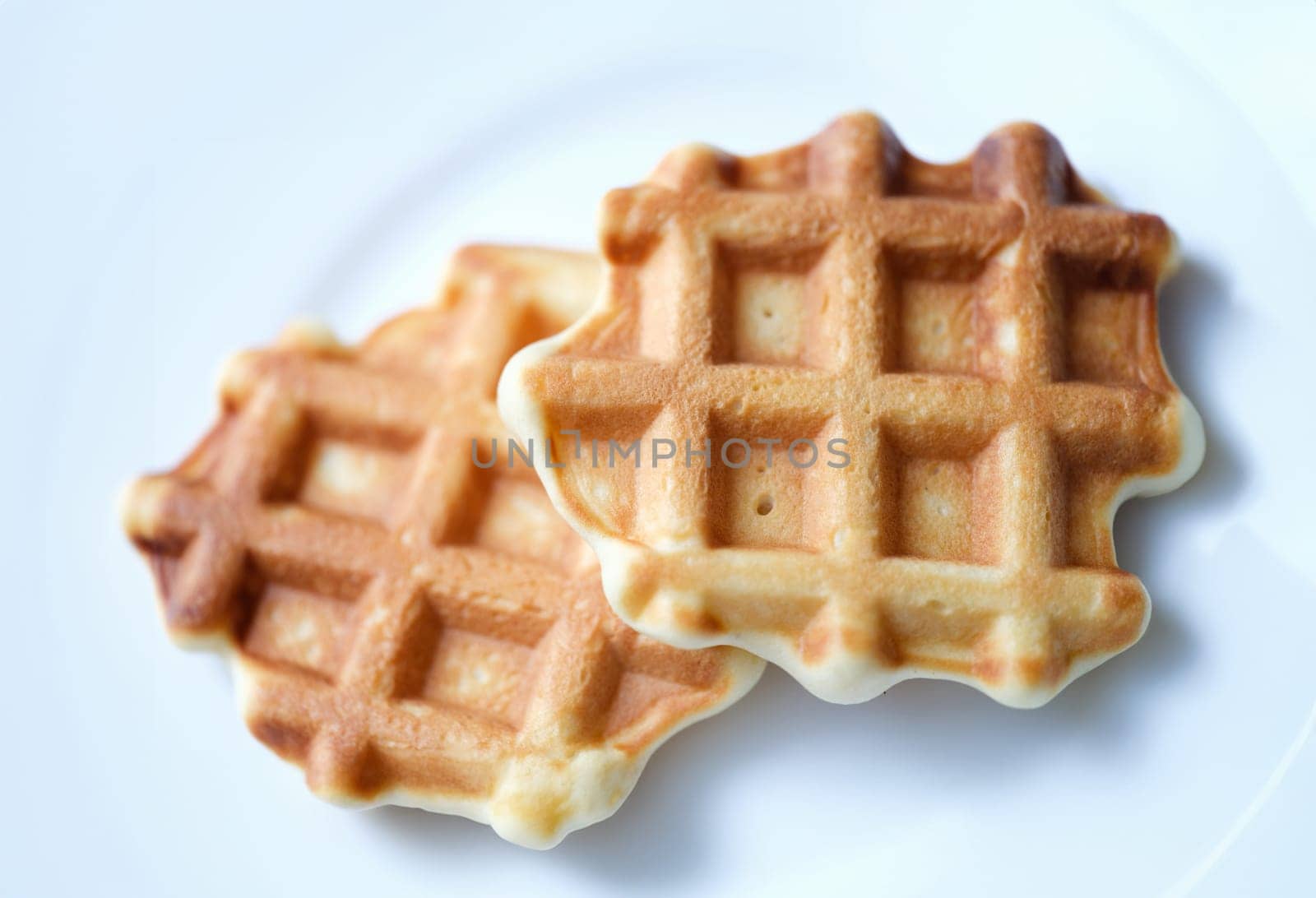 Homemade Belgian sugar waffles on plate. Cooking delicious waffles at home concept