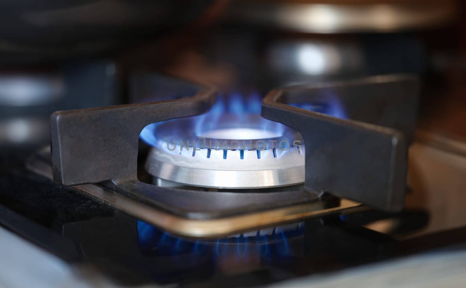 Gas burner on stove with blue fire at home closeup by kuprevich