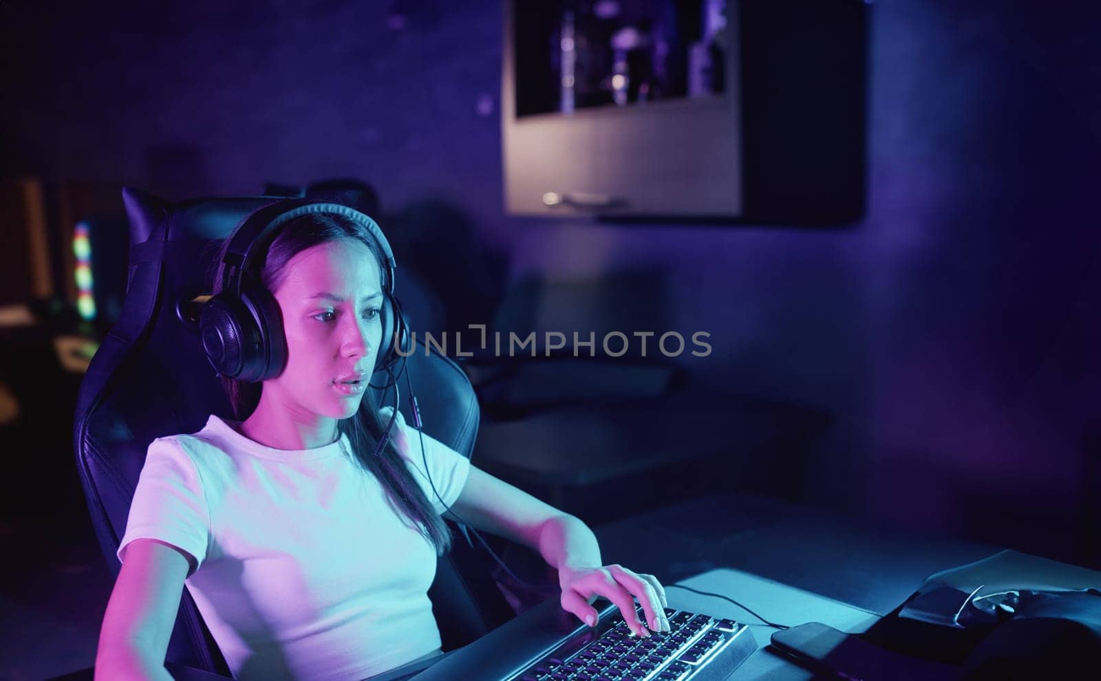 Girl gamer sits at the computer in the gaming club and playing by Studia72