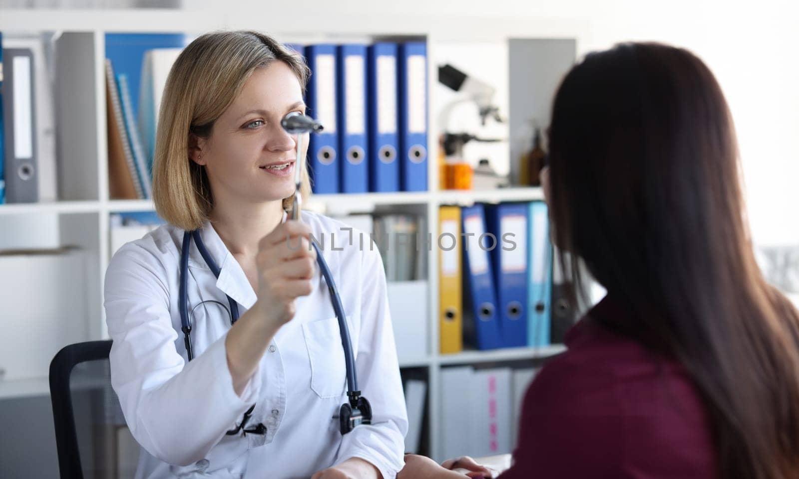 Neurologist holds hammer in front of patient eyes in clinic. Optic neuritis causes symptoms and treatment concept