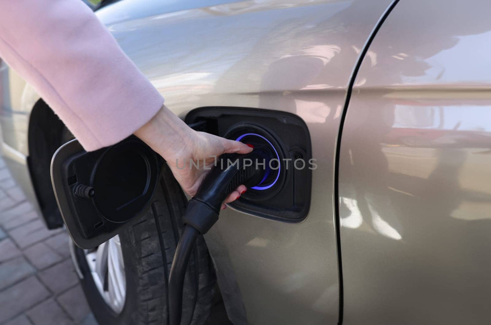 Woman hand holding charger for car closeup by kuprevich