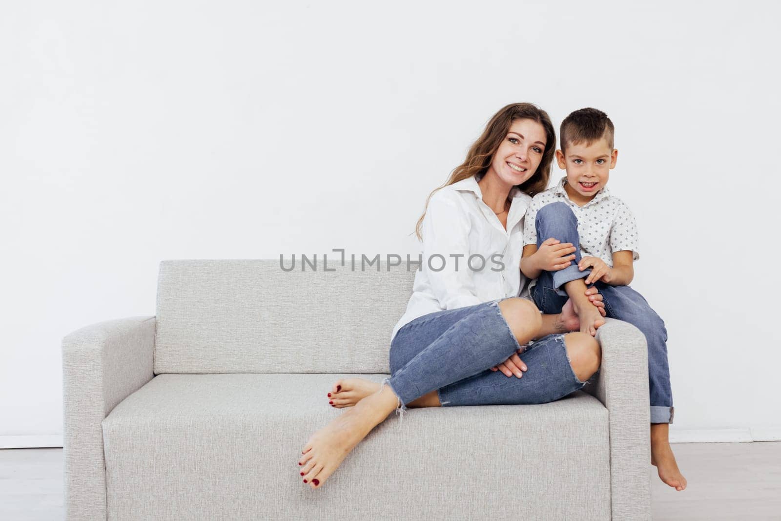 Mom with son resting at home on the couch white