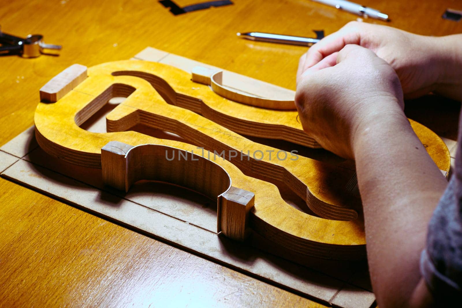 artisan violin maker luthier working on violin center bot, corner blocks , bend ribs for a new classic handmade violin using mold