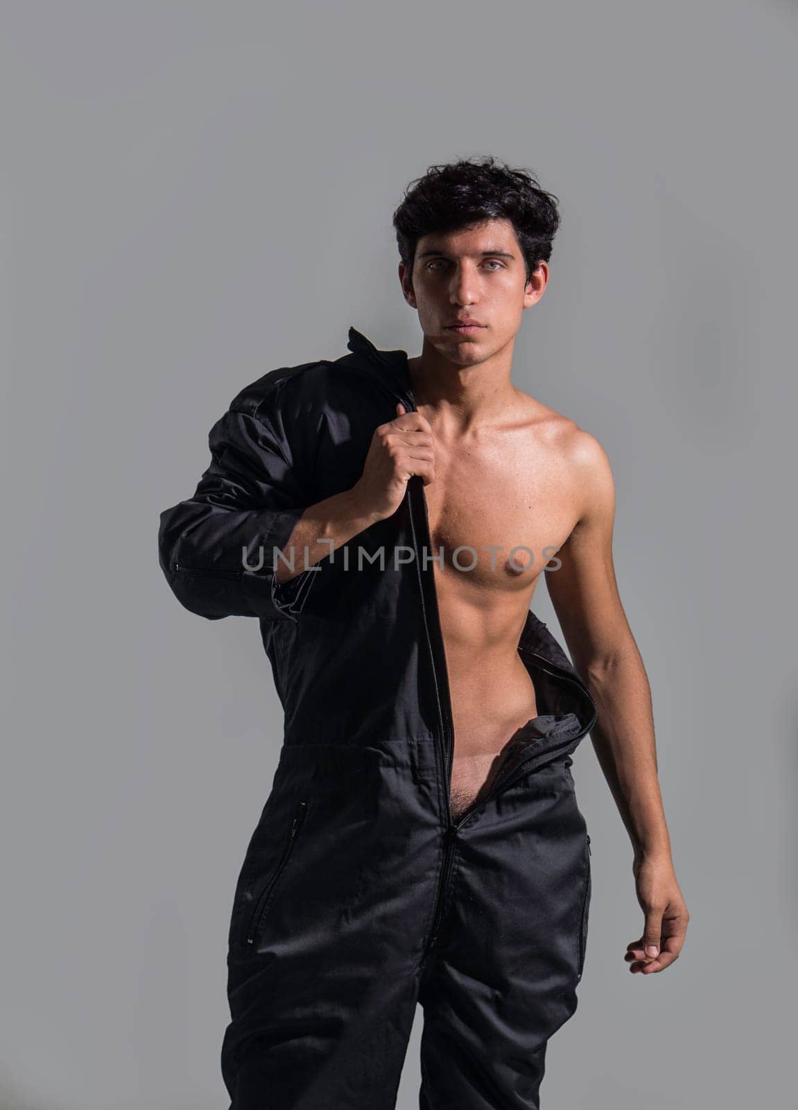 A Stylish Young Man Posing with Confidence, Holding a Jacket by artofphoto