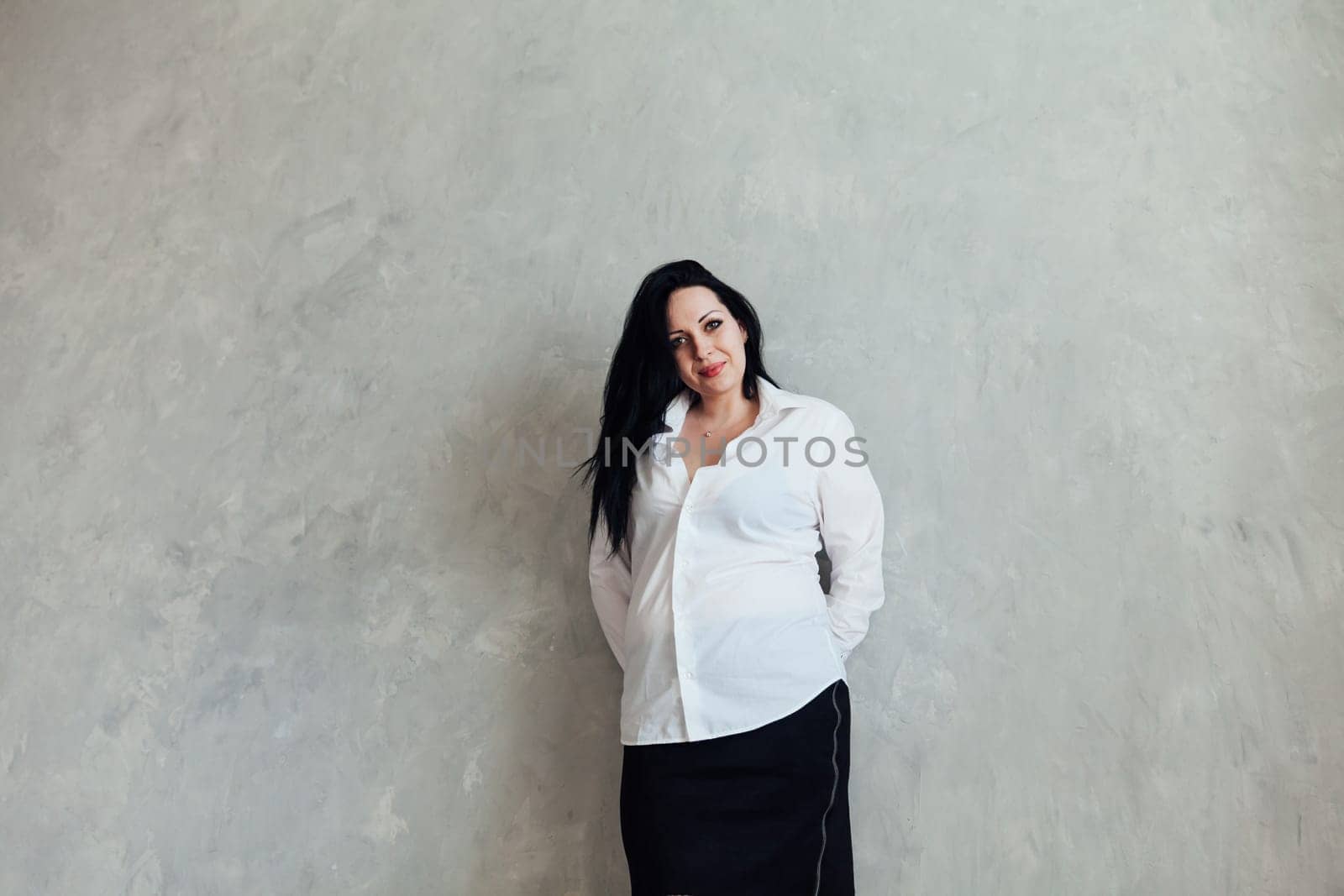 Portrait of a brunette woman in a white business suit
