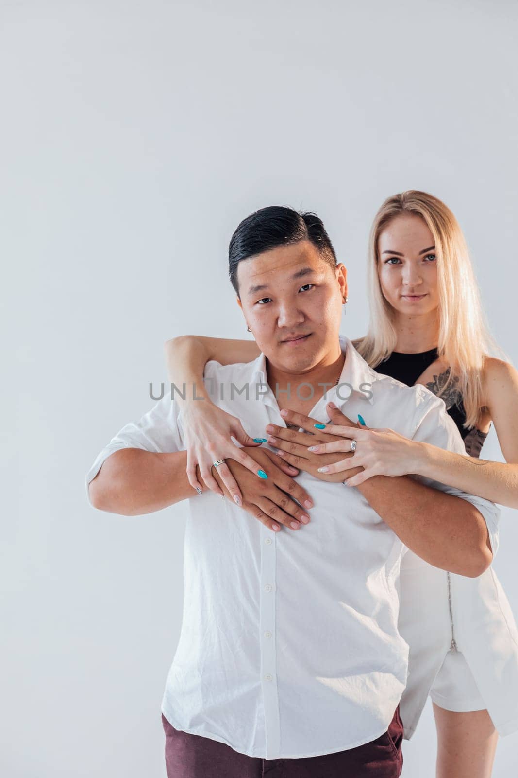 Man and woman couple lovers posing in bright room on white background by Simakov