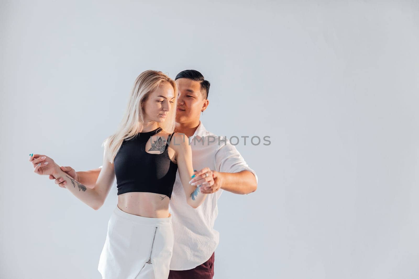 Man and woman dancers perform a dance on a white background