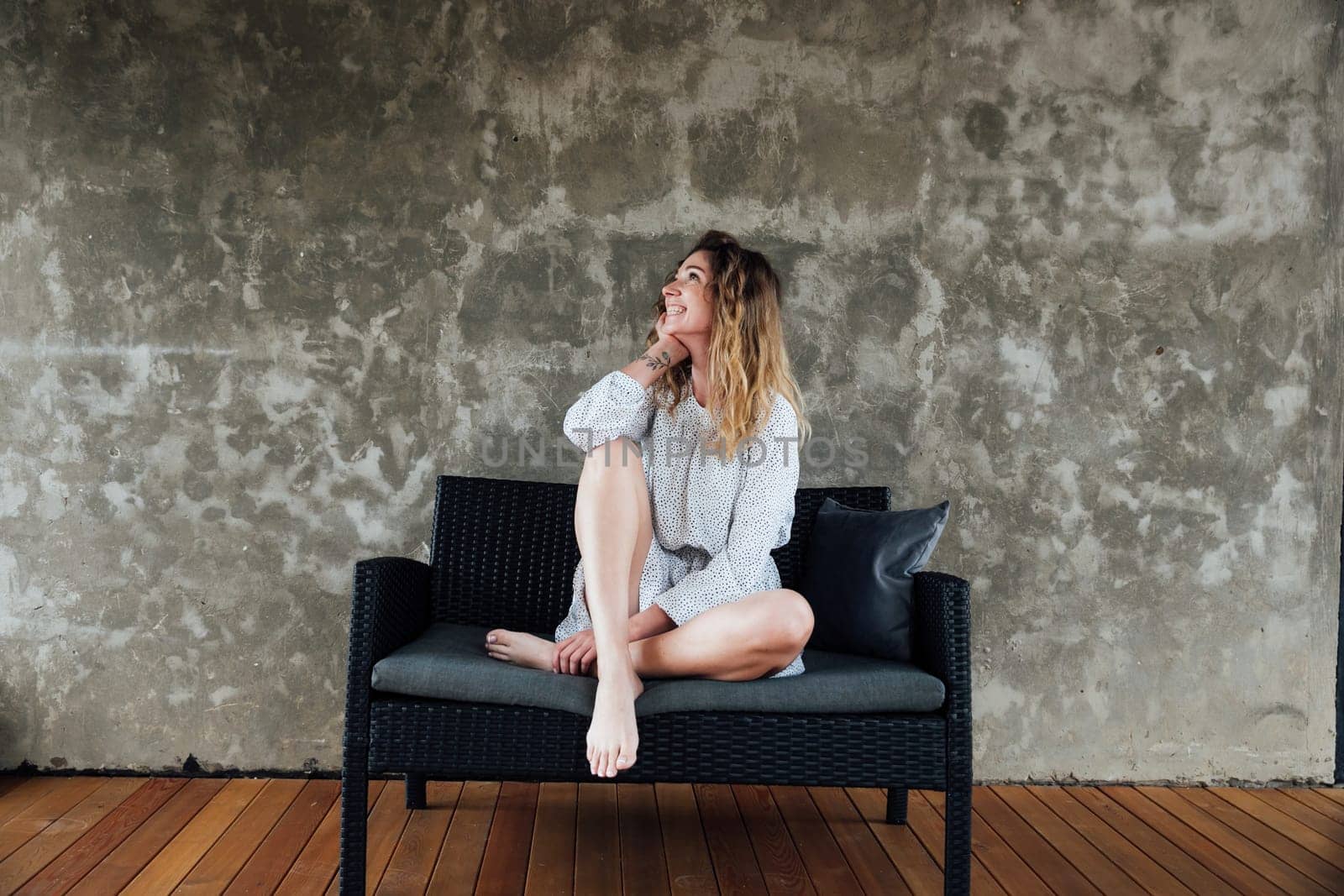 Woman posing on couch on gray