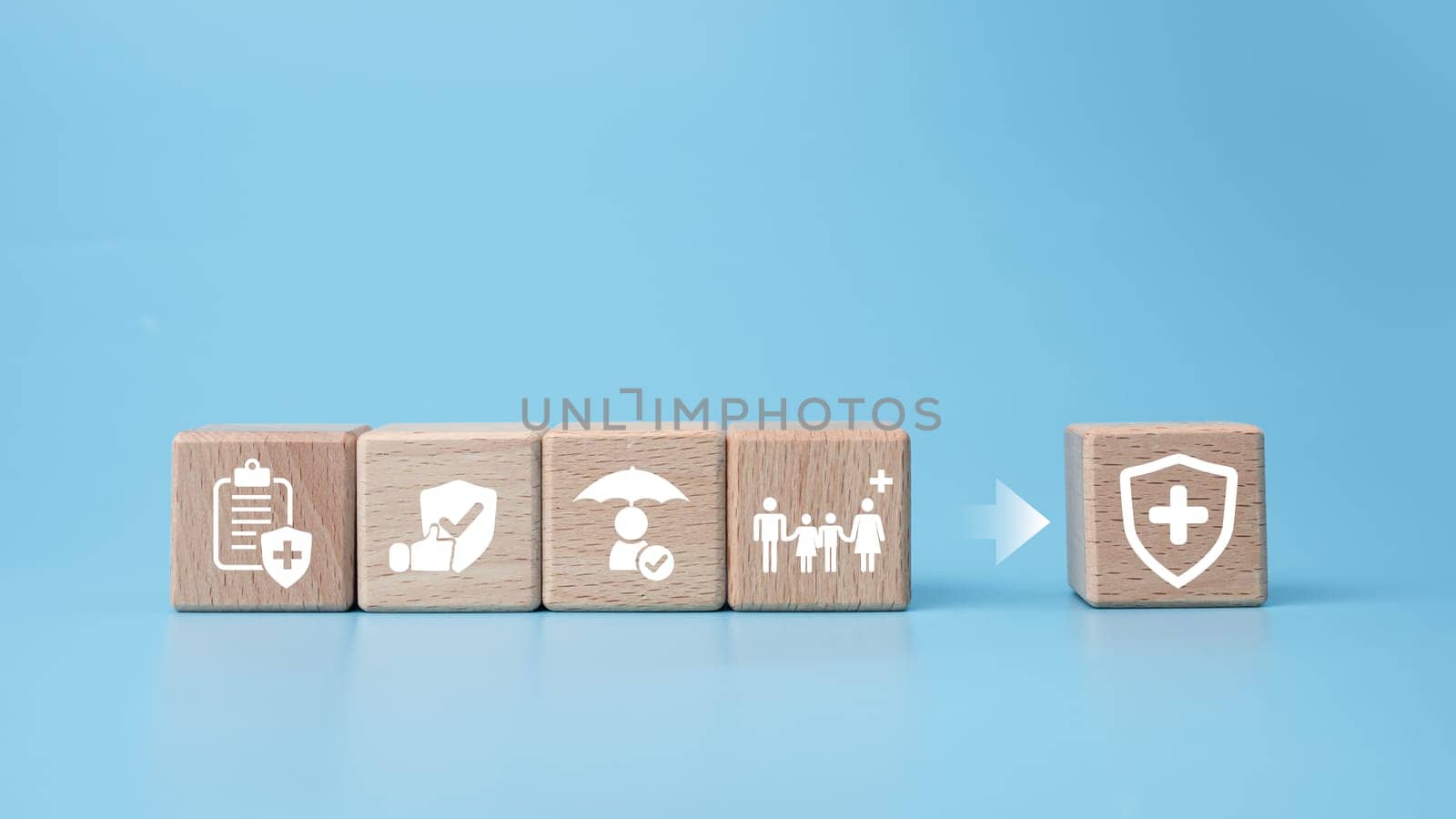 Concept of health insurance and medical. Wooden block with icons about health insurance and access to health care, health care planning on a blue background. by Unimages2527