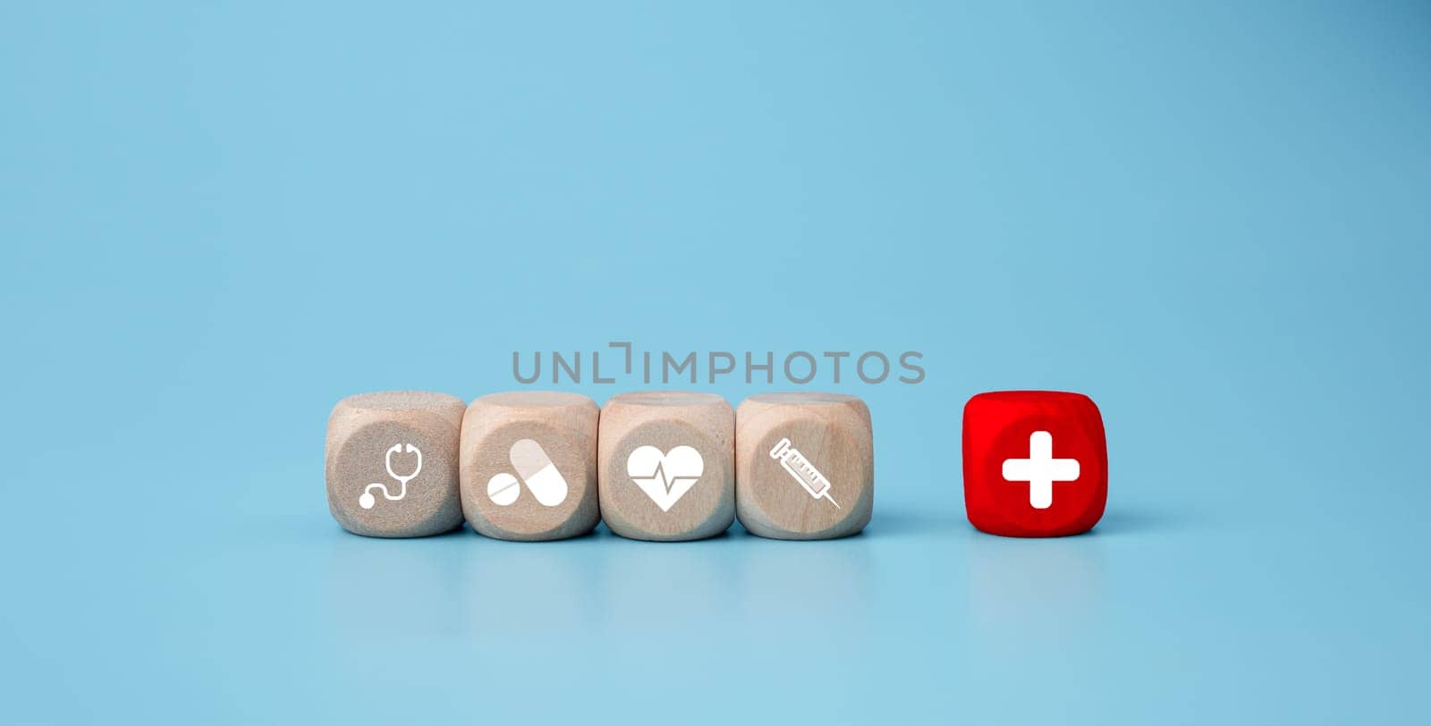 Wooden blocks with medical symbol icons on blue background representing health concept with treatment and medicine.