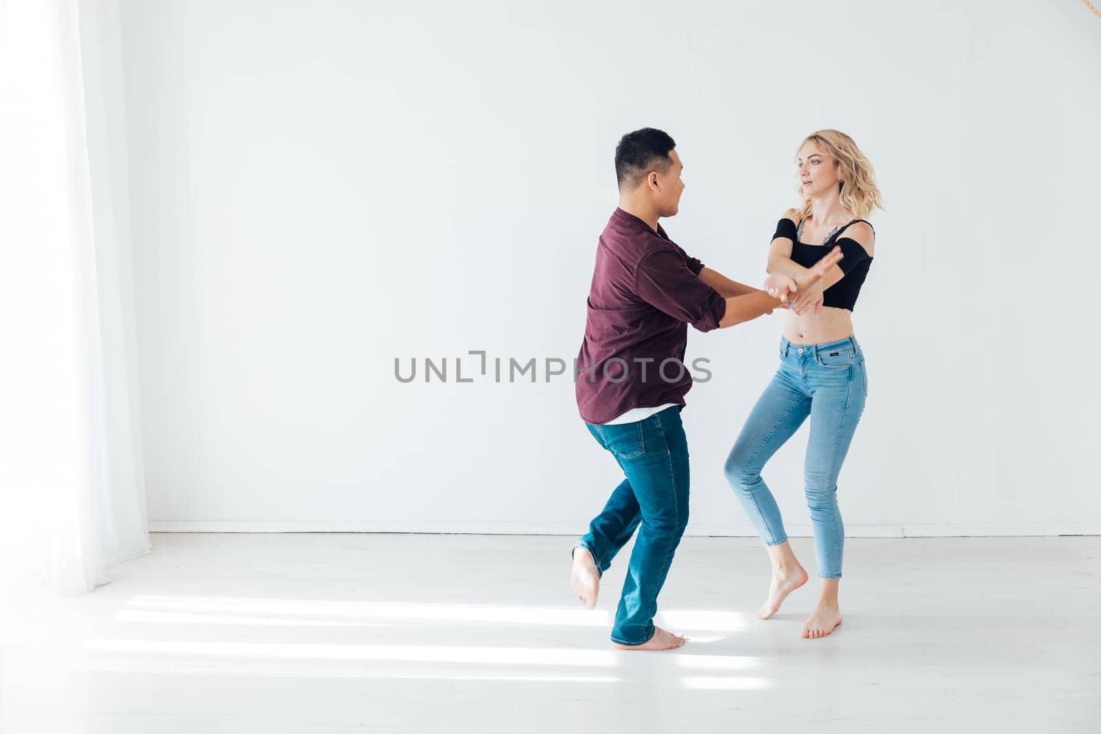 Training couple dancers man and woman dancing in studio by Simakov