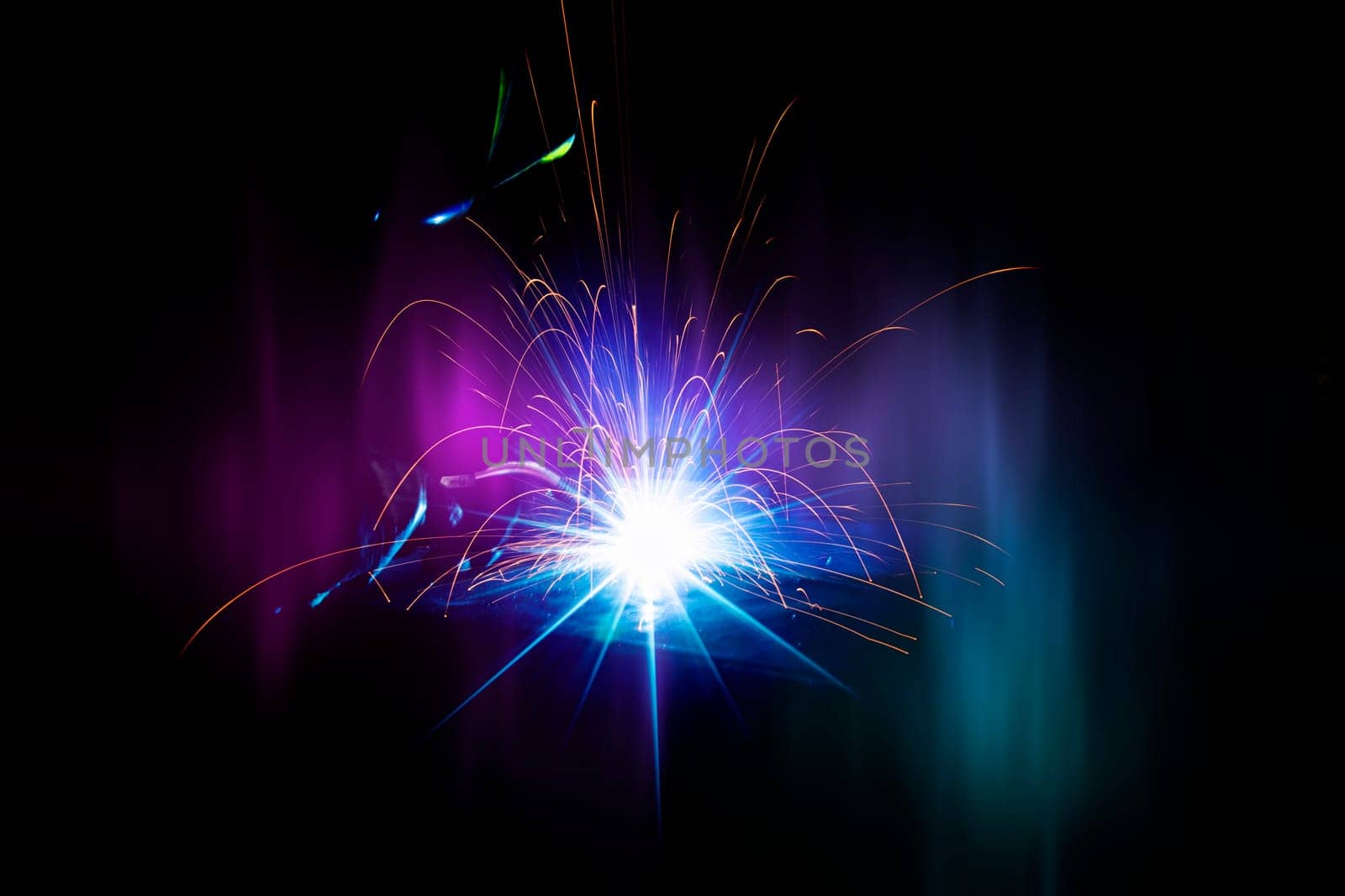Flying bright sparks from welding on a dark background.