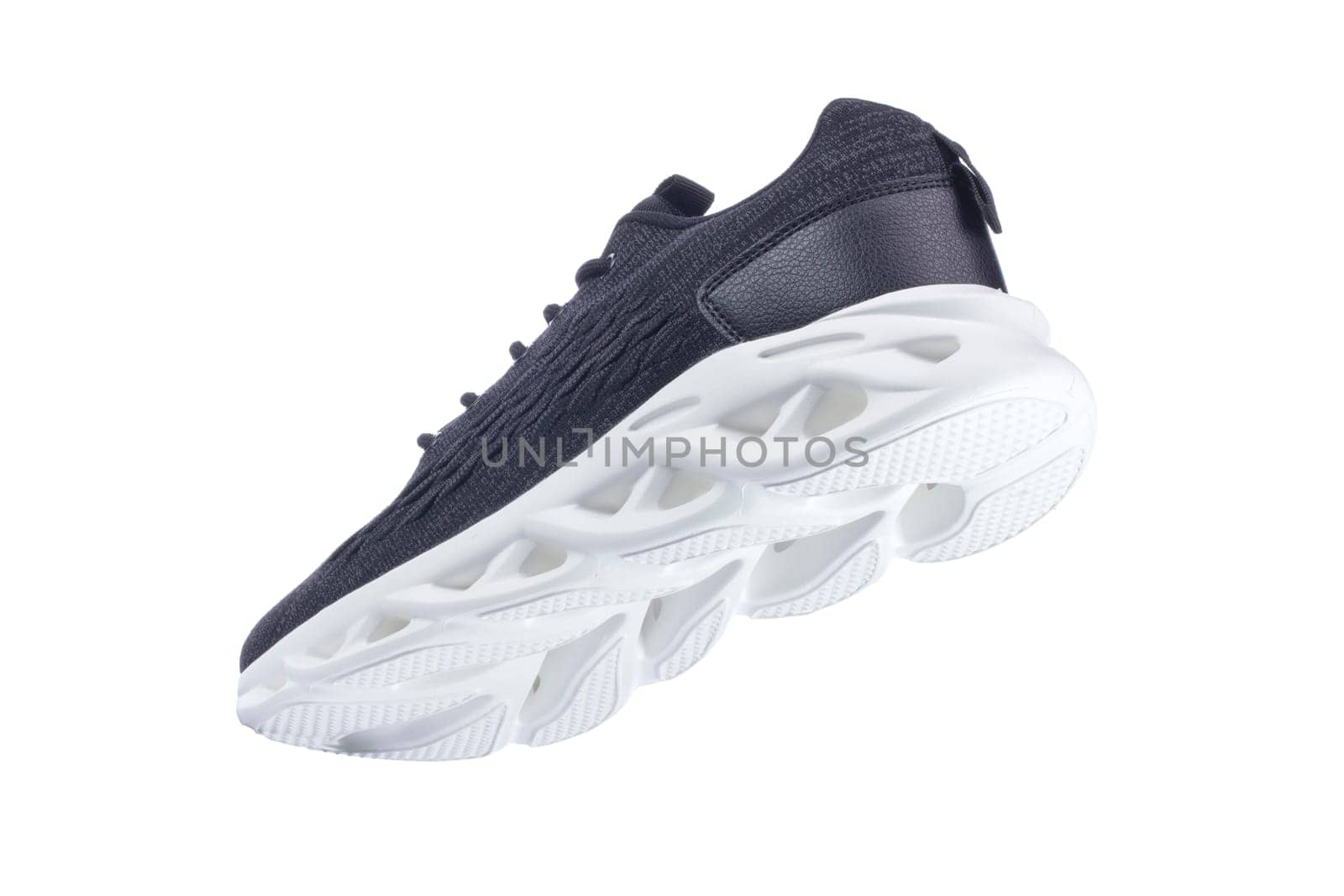 Black sneaker made of fabric with a white sole on a white shoe.