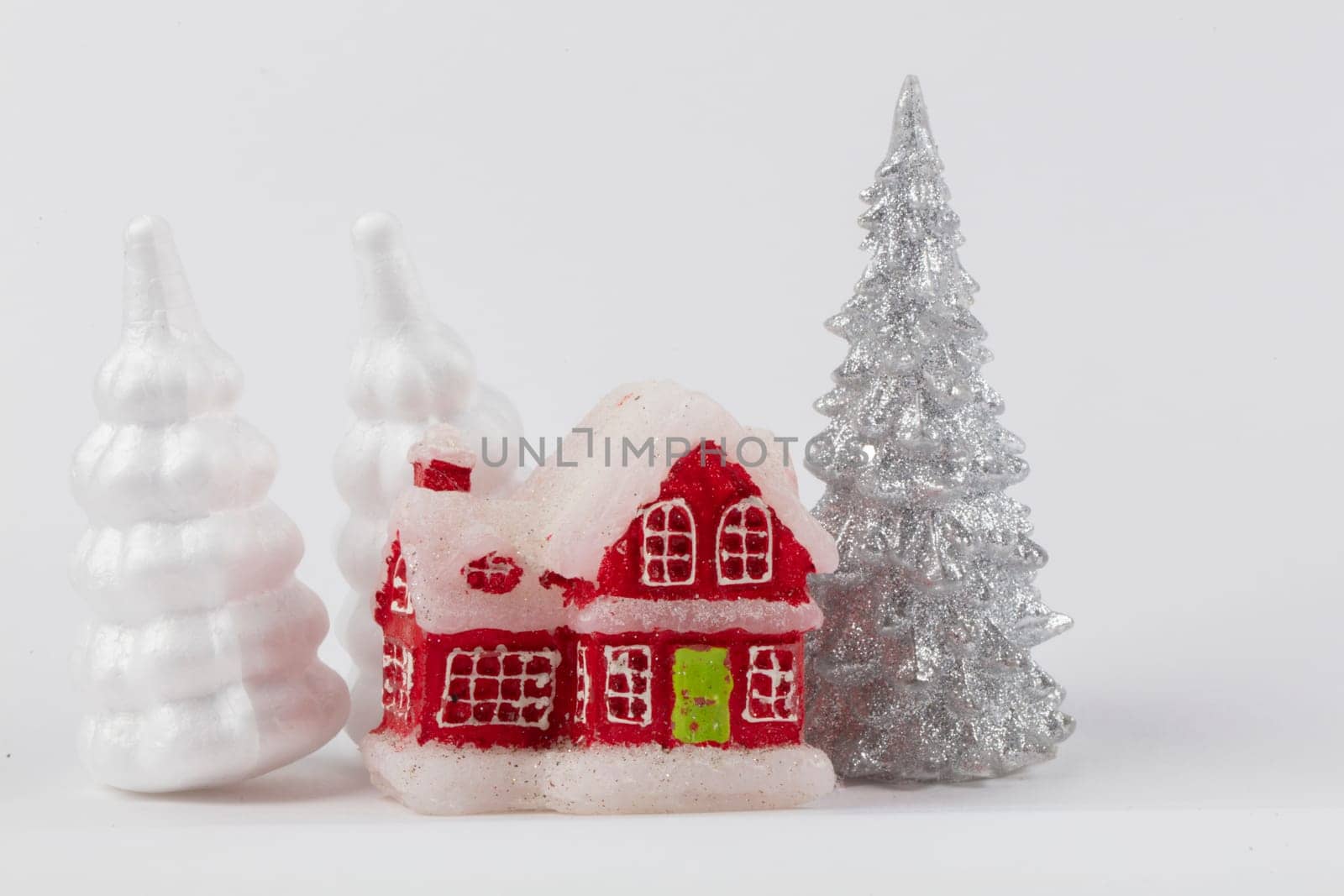 Christmas scene, miniature dacha village. Christmas little red houses, deer and snowy fir trees on a white background. Festive modern decorations. by Sviatlana