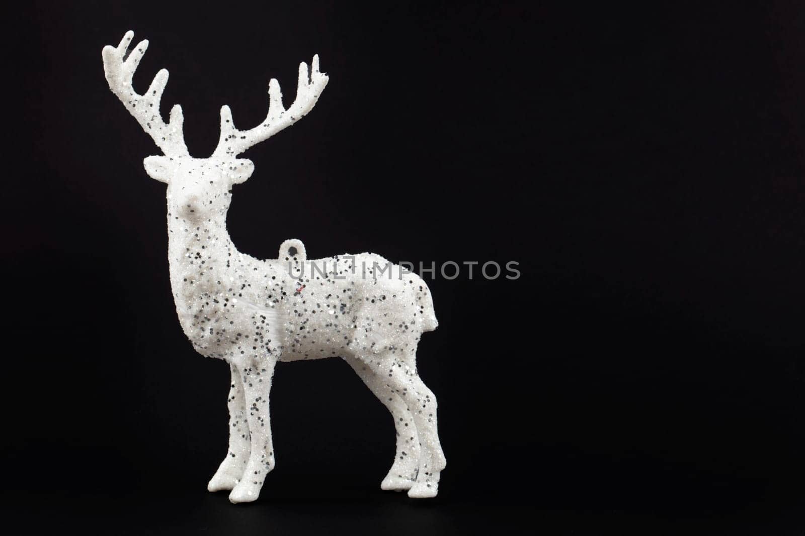 Festive dark Christmas background. White deer on a black background.