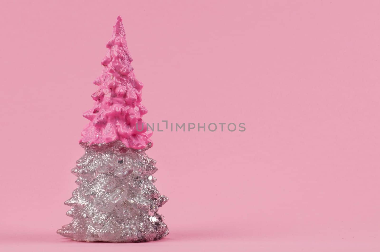 Christmas composition. Pink and silver Christmas tree on a pink background. Happy Holidays. minimal new year concept.