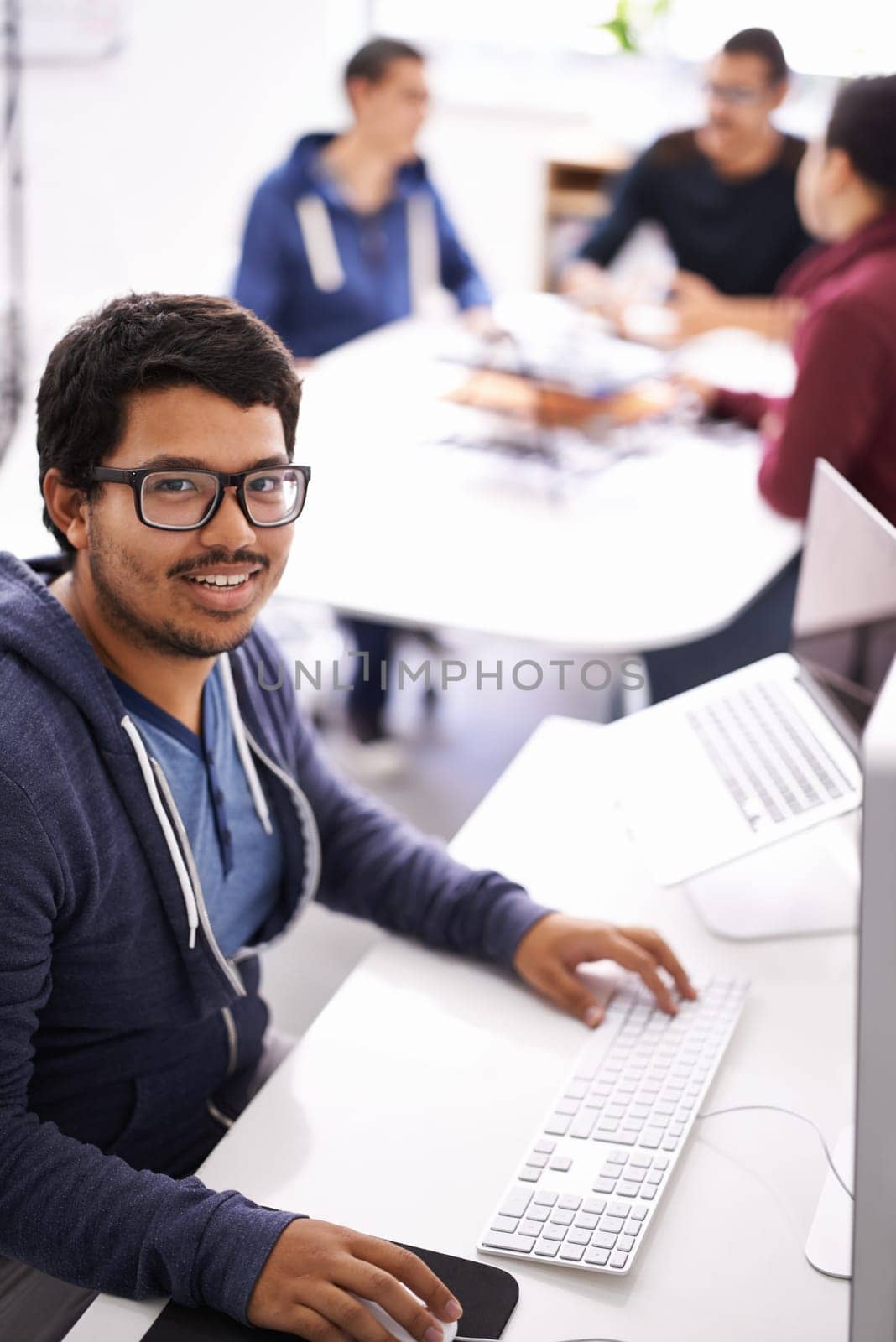 Hes a valuable member of the team. a young man working on his laptop in an office