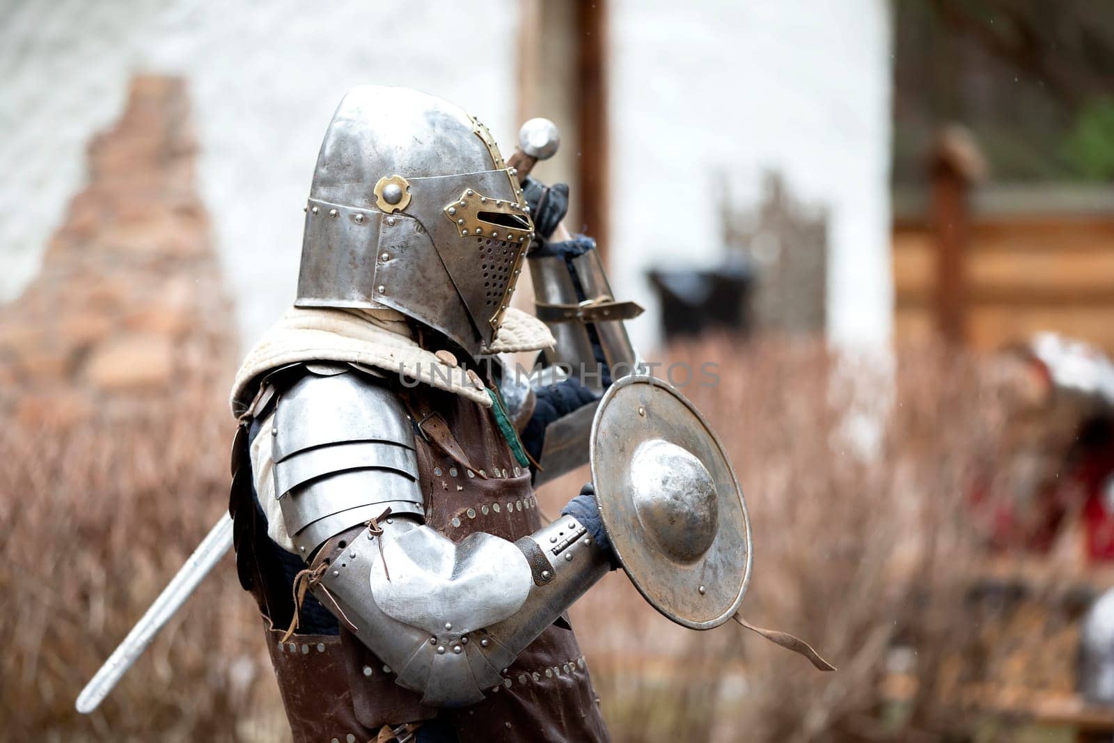 Antique medieval knight in armor with a protective metal shield. Iron age. by Sviatlana