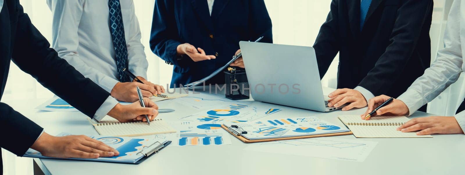 Business people in group meeting in formal attire share idea discussing report for company profit in creative workspace for start up business shot in close up view on group meeting table . Oratory .