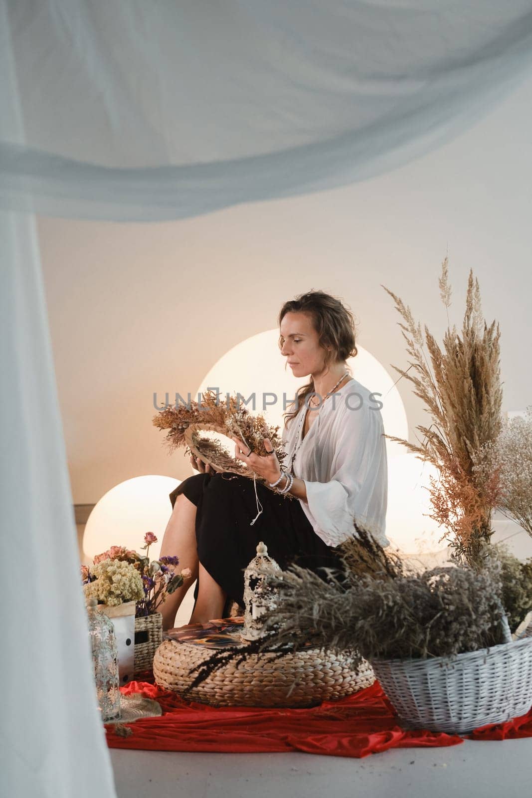 Women's circle and practice in the use of metaphorical cards. The girl is sitting surrounded by flowers.